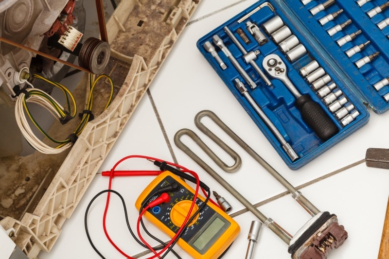 Engineer repairing a washing machine in Thames Ditton